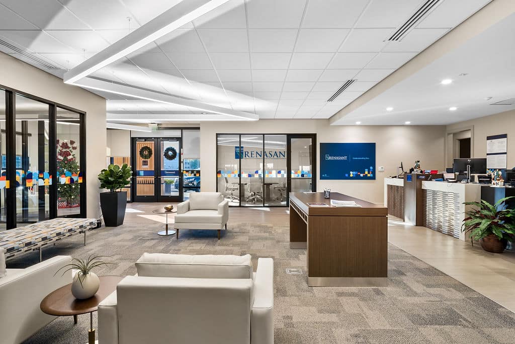View from the waiting area towards the reception desk, featuring a geometric light fixture.